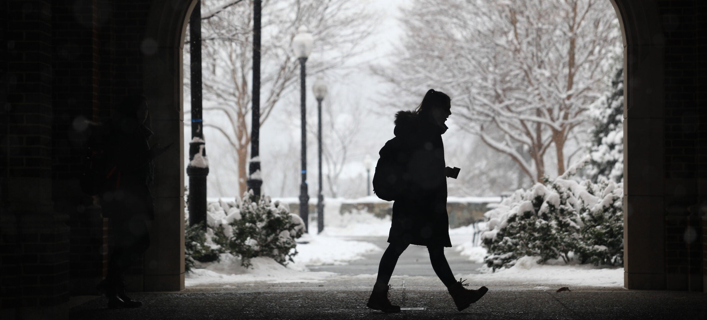 Woman happily walking in snow on a winter day